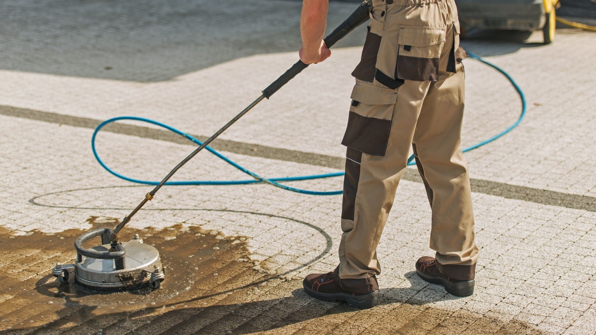 professional using pressure washer to clean concrete